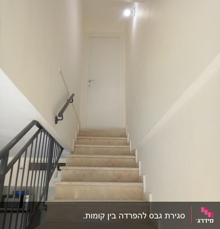 קיר גבס לבן עם מדרגות ומעקה מתכת